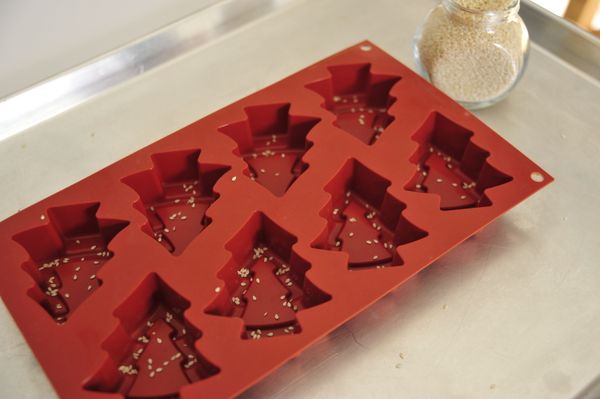 為了增顯抹茶的香氣，特別在烤模底部撒上少量的白芝麻，然後使用擠花袋或湯匙將麵糊挖進烤模鐘至8分滿左右。

麵糊填充完成輕敲烤模盤，目的是讓麵糊內的空氣盡可能排出，這樣成行會更均勻好看。

烤箱預熱至180度(華氏350度)設定烘培時間約21分鐘上下。

如果你是使用很淺的烤模，時間大約15分鐘左右就足夠。測試方式就是在接近出爐前1~2分鐘時間以竹籤刺入麵糊中央，確定無沾黏即可出爐放涼。