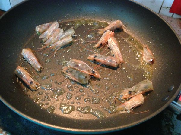 鍋裏放些橄榄油，把蝦頭扔下去炒壹下，讓蝦頭的味道融入油裏；這步驟對于意粉的味道很重要啊 ，蝦頭丟掉浪費。