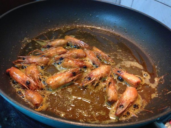 炸出蝦油的蝦頭撈起來，大叔沒浪費都吃掉啊 ！放些許鹽調味，味道非常不錯。