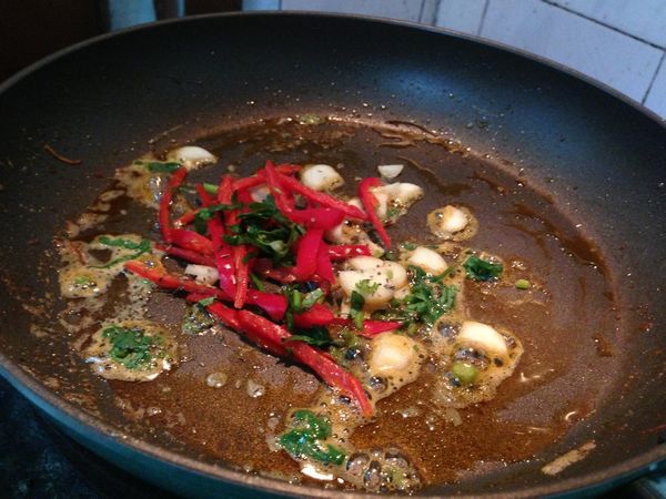 把蝦頭撈起來；鍋裏剩下的油爆香蒜片、辣椒絲、香菜碎、幹羅勒炒出香味（別炒糊了）；