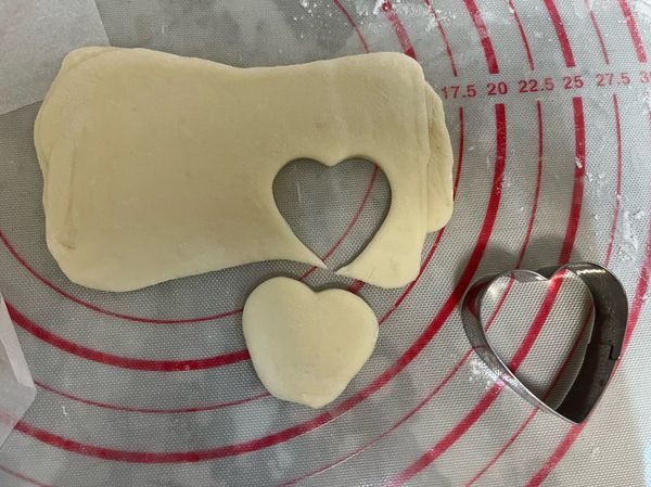 將剩下的白色麵團，桿平，用心型模型押出松鼠臉部，底部尖處去除，如圖示