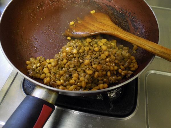 起鍋下少許油加黑胡椒粒炒香絞肉後(要炒到粒粒分明)下1塊牛頭牌咖哩塊，加少許的水、及玉米炒至水收乾、顏色均勻。