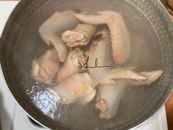 先拿出一個大鍋將水煮滾，放入雞翅，煮個2分鐘，將上頭髒物及血水去除。(我並沒有用水洗，而是市場買回來就直接這樣子作，因為感覺水也洗不乾淨!但是如果你想要用清水洗淨再直接放入鍋內煮，省去這步驟也是可以的。)