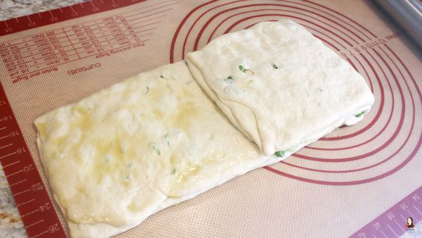 從麵皮右邊折過來包住蔥花內餡、壓一壓