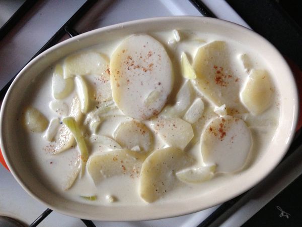 在烤盅內依序鋪上圓鱈與馬鈴薯,並將鍋內的奶汁倒入(倒到8分滿就好,以免滾沸的奶汁溢出容器)