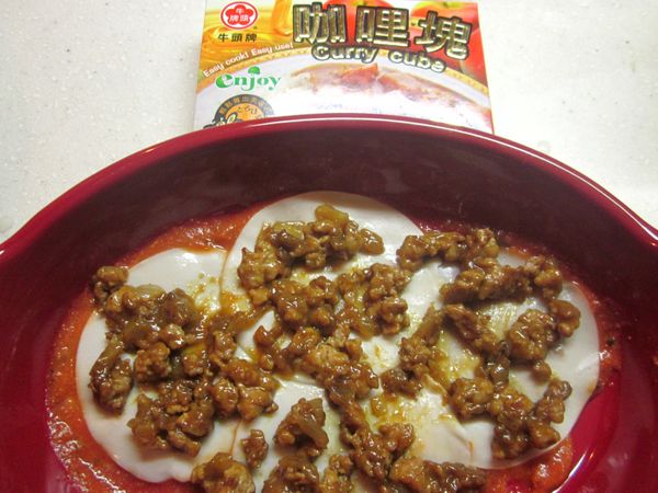 烤盤底部抺上蕃茄醬,水餃皮燙好一張鋪一張,鋪完整個烤盤後放咖哩肉醬.