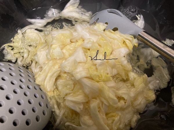 1小時後，高麗菜縮小了，倒入1000CC冷水，拌一拌或用手抓一抓把鹽份都沖洗掉。