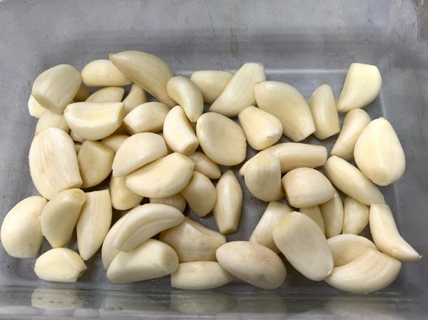 蒜瓣去蒂、去蒜衣，清洗後擦乾放入可進烤箱的容器。
