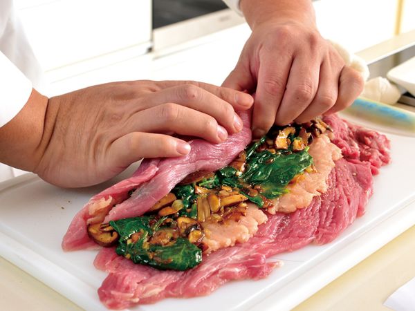 將鋪好內料的小里肌捲成圓柱狀，用料理繩將肉卷綑綁固定。