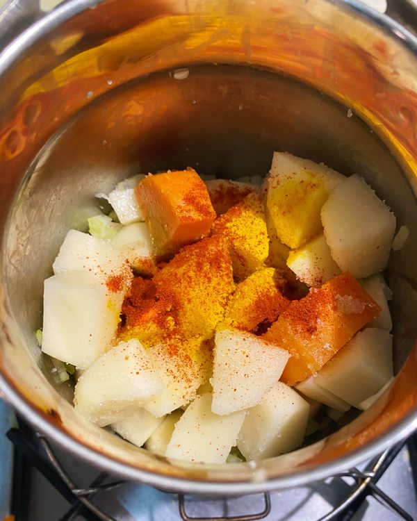 然後放入紅蘿蔔、馬鈴薯與西洋芹和細砂糖與所有香料一起拌炒均勻。