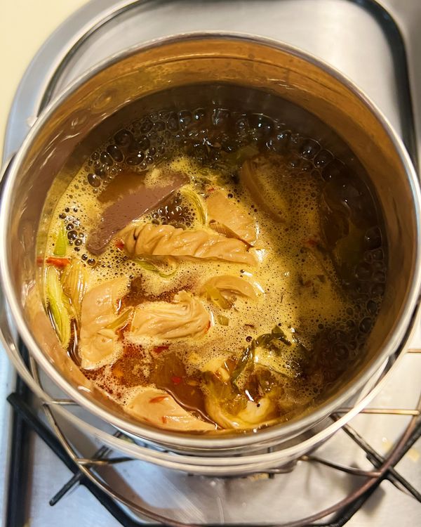 放入辣豆瓣醬、醬油炒香，再放入大腸頭、鴨血，淋入米酒炒一下。再加入高湯與其他調味料煮至大滾。