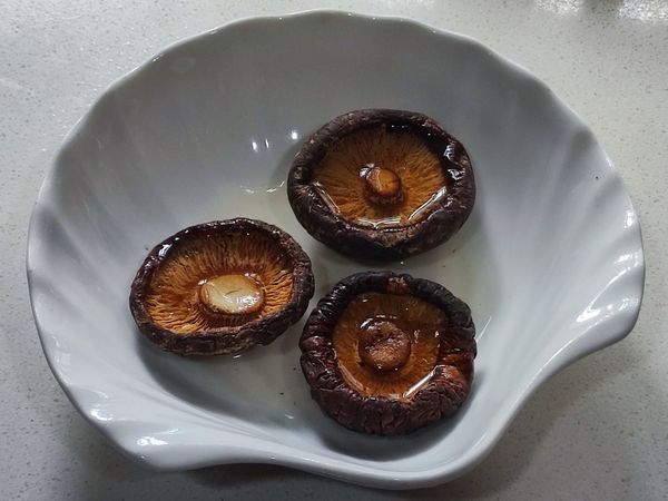 在乾香菇的菇傘上加水，使香菇軟化