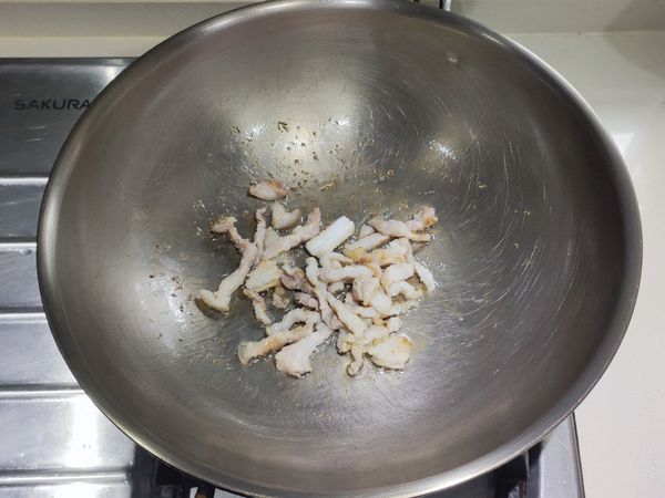 鍋子熱鍋後轉小火，再加入植物油。然後加入五花肉絲，將肉絲中的油煸出。