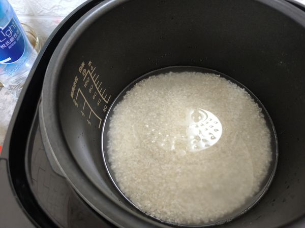 米洗好，瀝乾水份，倒入電鍋內鍋中後，加入礦泉水和雞粉攪拌均勻，備用。