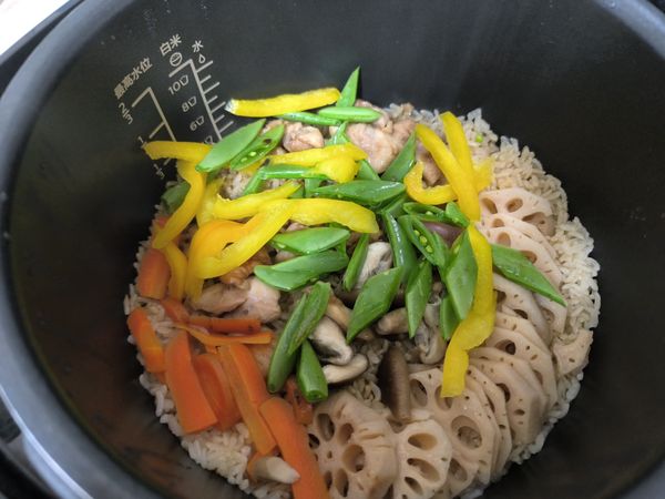 米飯煮好後，將切好的黃甜椒和甜豆筴放入電鍋中，蓋上電鍋蓋燜10分鐘。