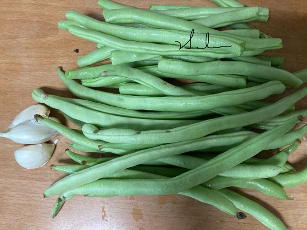 把四季豆頭、尾用手折斷順著拉下絲丟棄。再洗淨