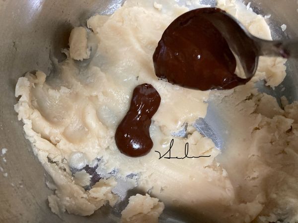 將融化後的巧克力放入白豆沙和椰子油中用手拌勻顏色。=巧克力餡。