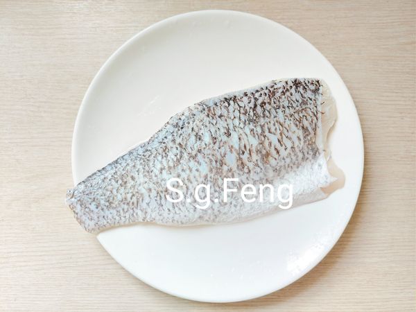 2.鱸魚排包裝(不拆封)直接以冷水可蓋過鱸魚排的水量浸泡至變軟解凍即可；解凍完成再清洗，確認鱗片是否完全去除，完成後以[醃料]均勻的抹於鱸魚片的兩面，醃漬３０分鐘。