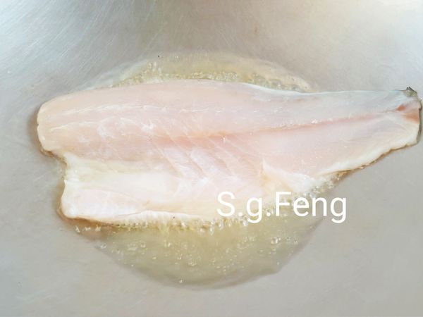 5.起鍋，開中小火，倒入食用油；油熱後放入鱸魚排(皮面先朝下)，先不動魚排，煎約4-5分鐘。