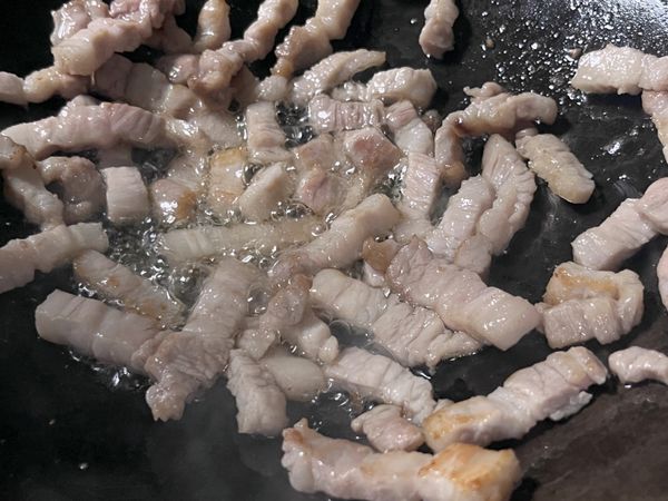 冷鍋下豬五花，炒出油至兩面金黃