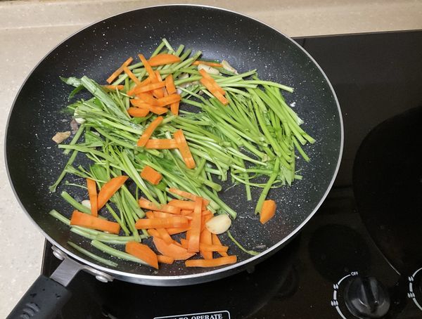 沙拉油炒胡蘿蔔、蒜頭、薑片跟空心菜梗