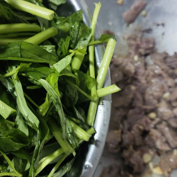 倒入牛肉拌炒，待牛肉8分熟，將空心菜洗淨切段，放入鍋中拌炒。