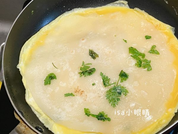 把蛋餅皮鏟起，倒入蛋液，再蓋上餅皮。