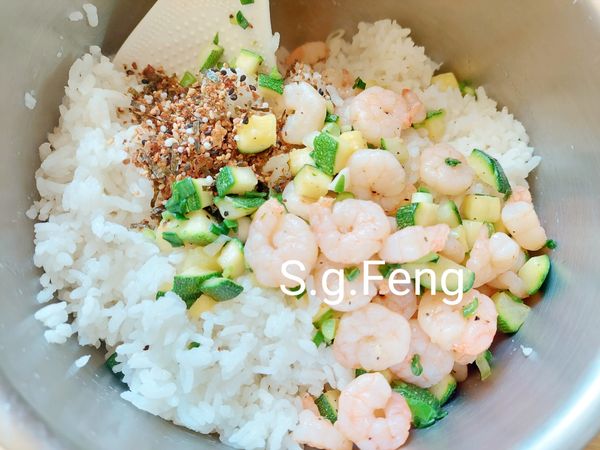 14.步驟6.完成的米飯取出鬆飯，再加入步驟13.完成的櫛瓜蝦仁與蝦仁口味拌料及胡麻油。