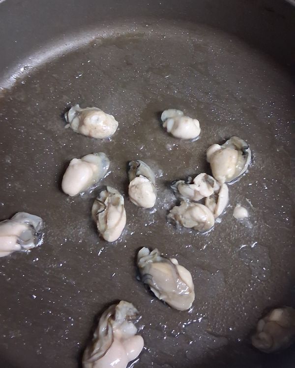 平底鍋加0.5大匙油，油熱下約十顆的蚵仔煎至半熟。蚵仔盡量平均分佈。