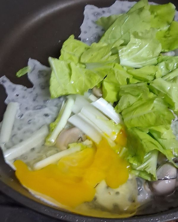 倒入兩大湯匙的粉漿,打入一顆蛋，用鏟子把蛋弄散，放入適量小白菜。