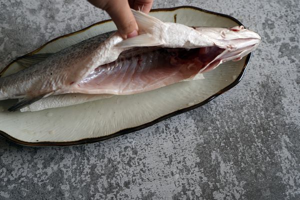 鱸魚退冰、洗淨
切刀花更快入味：正面畫2個X、反面深切一刀