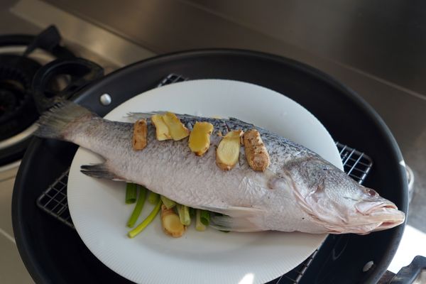 鋪薑蔥＋放上鱸魚，大火蒸 8–10 分鐘（魚肉超嫩！）