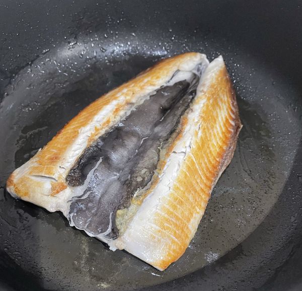 側邊看到魚肉變白色後，轉小火，將魚肚翻面，蓋上鍋蓋，轉中火續煎5分鐘，煎至魚肚熟透。喜歡恰恰口感的，可以翻面再煎一下。