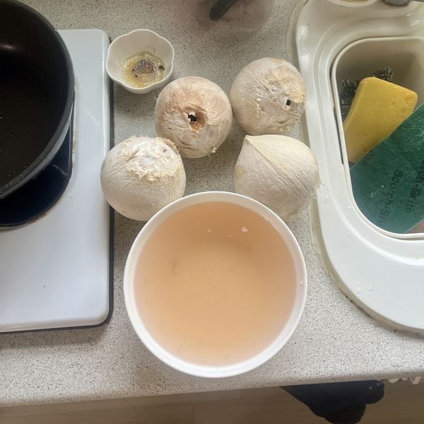 取出椰子裡的椰汁，蒜頭切碎備用。