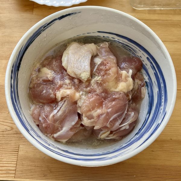 雞腿肉切塊，加入米酒及鹽抓醃靜置。