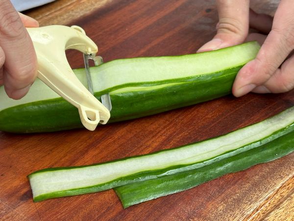 小黃瓜用削皮刀刨成薄片。