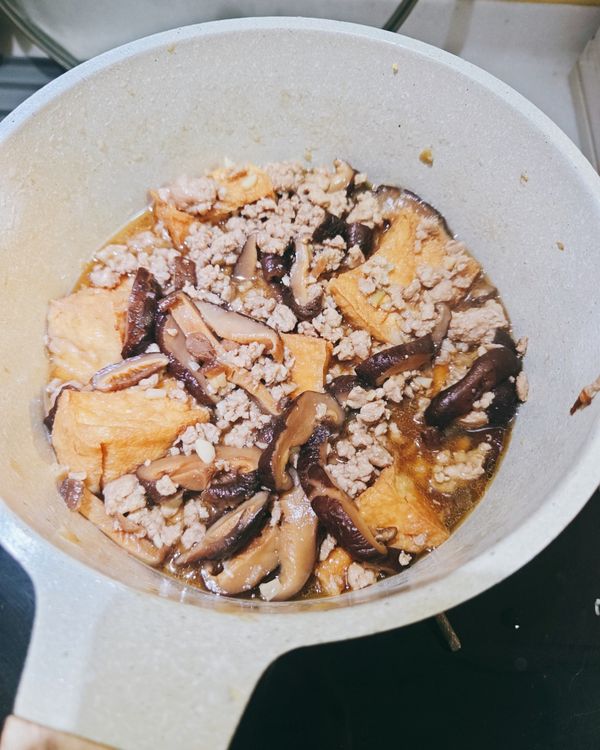 加入全部調味料和香菇水、油豆腐，燉煮15分鐘，試試味道依口味再加醬油或水