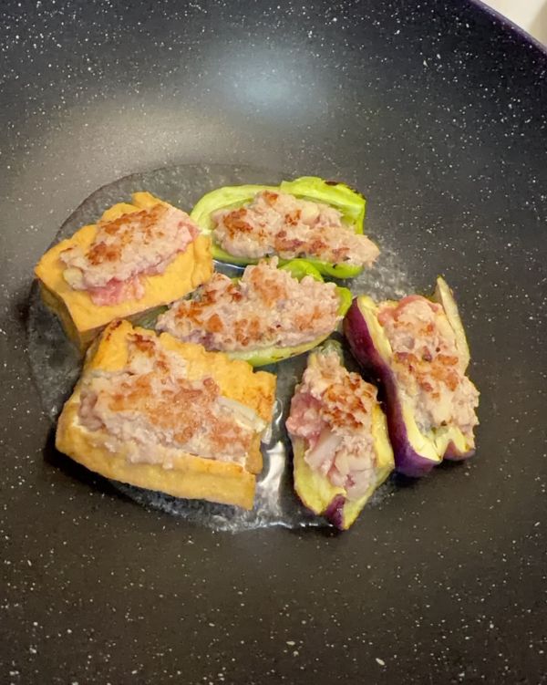 熱鍋以後倒油，將肉餡朝下放入鍋中煎，接著倒入水、蓋上後讓食材在鍋中燜煮直到水收乾，可以在此步驟加入適量醬油或其他醬汁一起燜煮

❗️留意火候大小，青椒皮和肉餡容易燒焦
🌟可以用筷子輕戳肉餡，沒有冒出血水=已熟