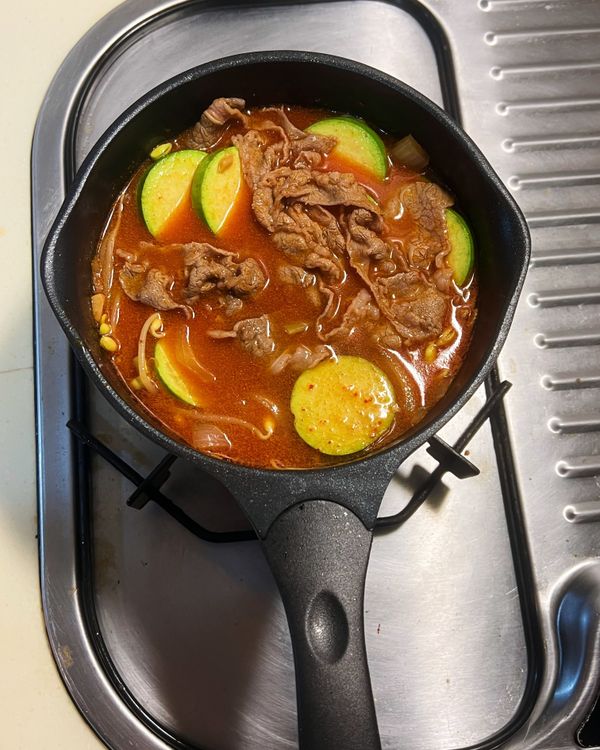 放入高湯、黃豆芽與韓式櫛瓜一起煮滾，轉小火煮約10分鐘。