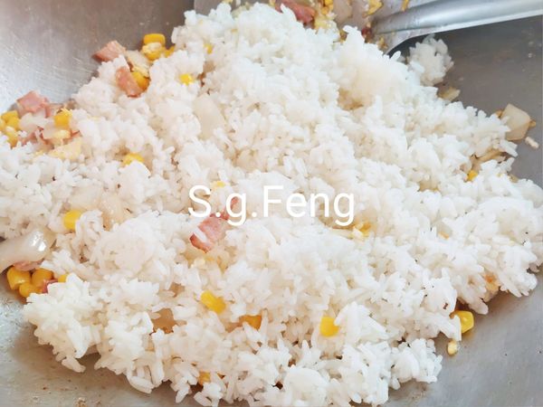 8.轉中火，加入白飯，將白飯拌散，翻炒至米飯蓬鬆（一粒一粒散開）。