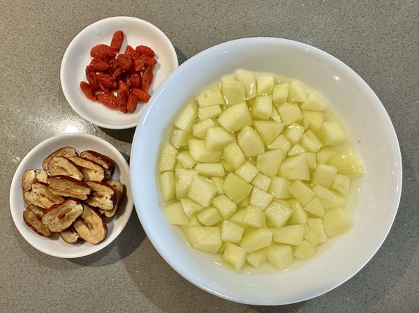 ●蘋果如果要連皮吃，洗蘋果我是這樣做，在手掌上灑鹽雙手握蘋果反覆搓蘋果外皮後沖洗乾淨，今天的蘋果茶想削皮吃口感比較一致，，泡在加1/5小匙鹽的冷開水中避免氧化。
●將紅棗和枸杞沖洗乾淨，紅棗用小刀對半剖開這樣可以縮短熬煮的時間更容易入味。