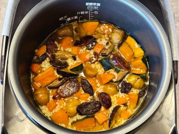 將炒好的米料倒入電子鍋內鍋，加入香菇泡水+過濾水至2米杯刻度線，稍微攪勻。按下〈白米〉或〈炊飯〉模式，靜待炊煮完成～