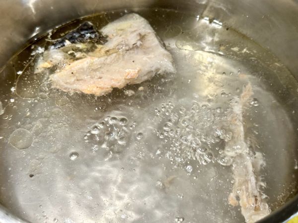 ●起湯鍋，把鮭魚尾段魚骨放進湯鍋中當煮麵的油脂，在湯鍋中加1/2小匙鹽(不在材料裡)，湯鍋水滾放麵條煮至喜歡的熟度。