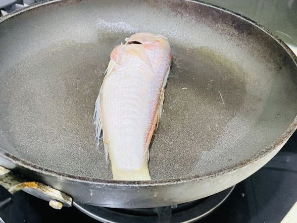 熱鍋肉油後，放入馬頭魚，火轉中小火後就先靜放~避免移動，待一面有煎到變色後，再翻面