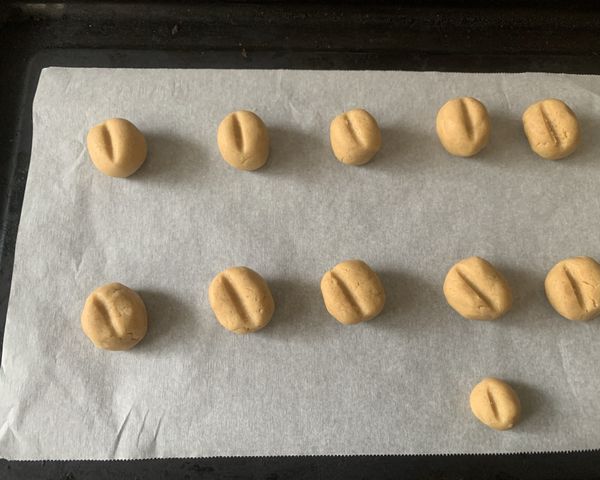 將麵團搓圓並放在烤盤上
分成10g一顆 ，中間用筷子壓一個橫線
160度烤約15分鐘至金黃色