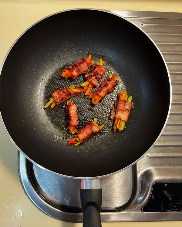 放入培根捲，煎至表面焦香後，取出牙籤。