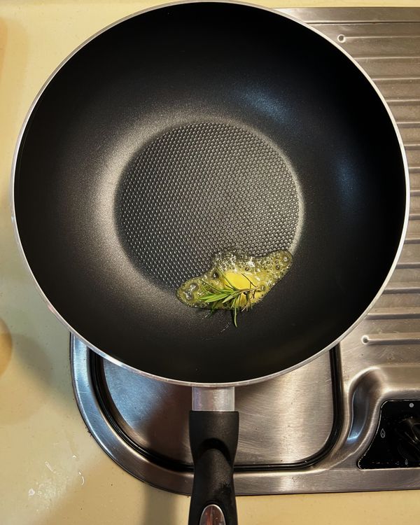 鍋中放入無鹽奶油、橄欖油與迷迭香小火加熱。