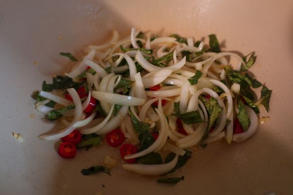 炒鍋熱油，炒香咖哩葉、洋蔥、辣椒和蒜末。