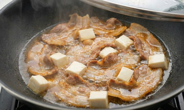 1.放入 1 大匙砂糖，炒至融化起泡。

2.沿著鍋邊淋入 2 大匙醬油、1 大匙米酒，快速
   翻炒讓肉片均勻上色。

3.放入切好的嫩豆腐塊，加入約半碗熱水轉小火，
   蓋上鍋蓋，燜煮 5 分鐘。