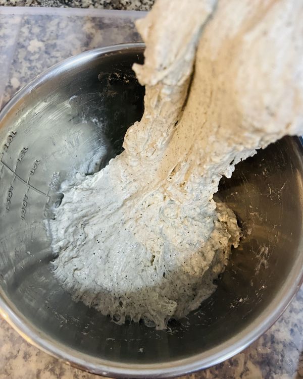 30分鐘後，手沾濕拉起麵糰的一角，往中心摺；